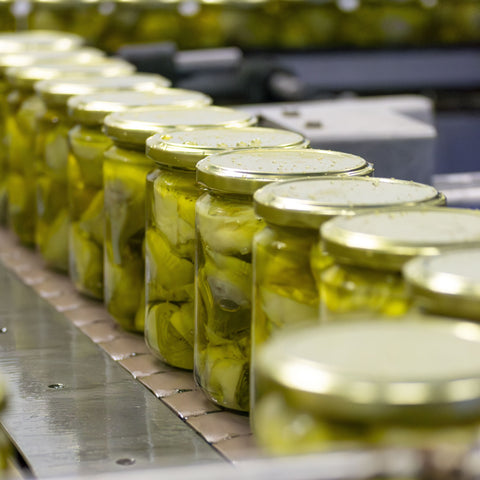Tarros de corazones de alcachofa recién llenados con aceite de oliva